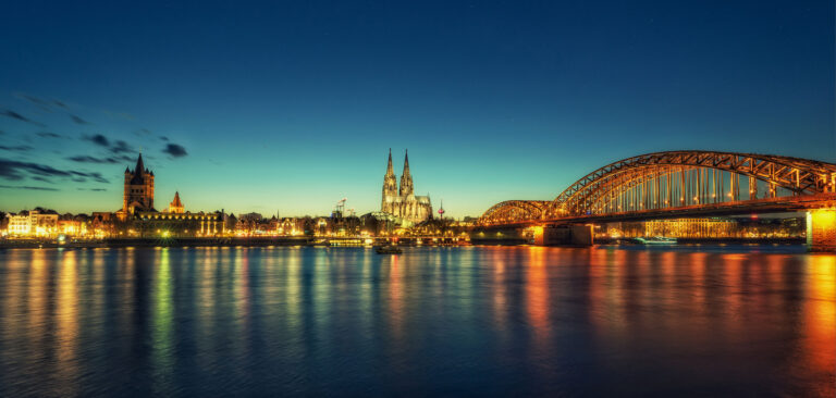 Nächtliches Panorama über dem Rhein auf Köln mit Blick auf den Dom, Hohenzollernbrücke. Eine pulsierende Stadt mit urbanem Publikum und Ideal für Werbung und Marketing-Aktionen für Musikindustrie, Filmindustrie und Fernsehen.